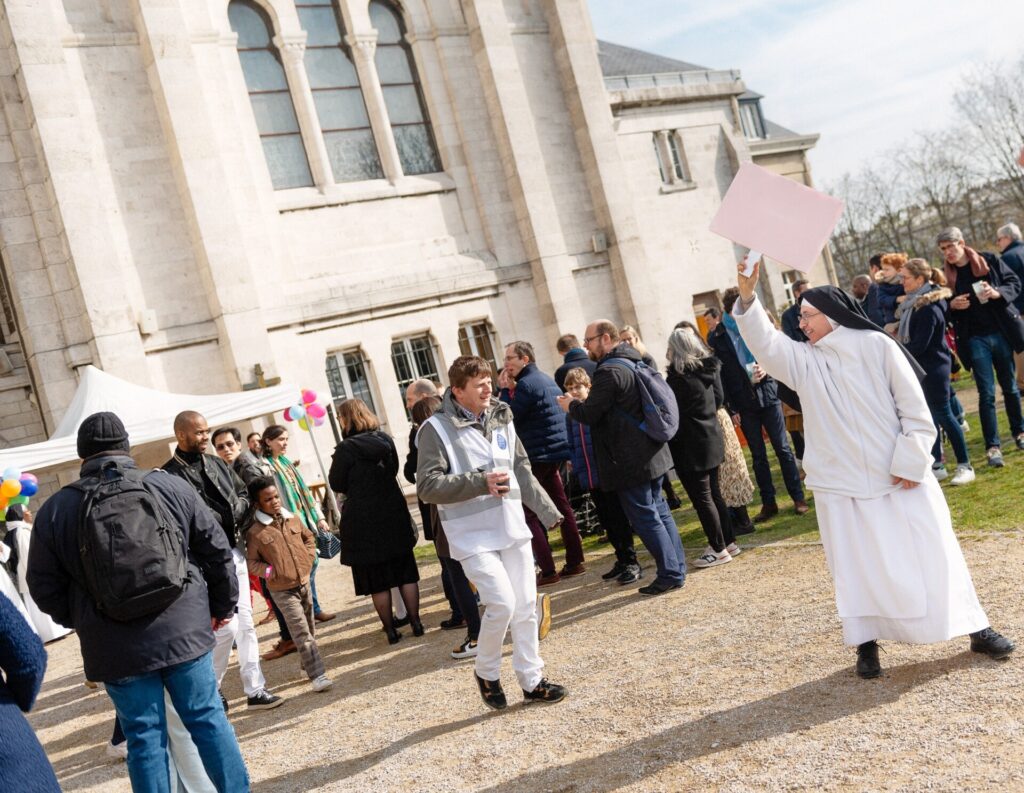 Soeur bénédictine participant à la montée des familles et invitant les familles à la suivre